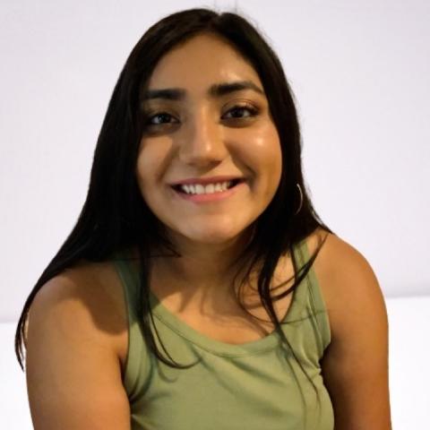 Woman in green tank top smiling with a white background